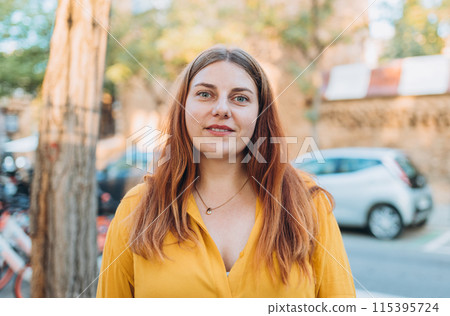 Portrait of beautiful cute woman on urban background. Young woman smiling confident standing at street 115395724