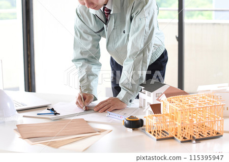 Asian man in work clothes designing a building 115395947