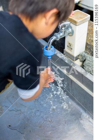 A child washing his hands at the tap A child washing his hands at the tap 115396169