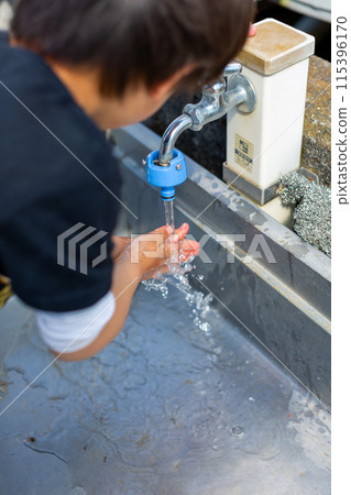 A child washing his hands at the tap 115396170