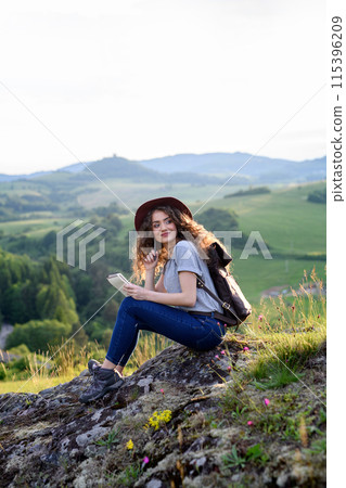 Young tourist woman traveller with backpack in nature, sitting and resting. Active hiker on trail in mountains enjoying breathtaking view. Young tourist woman traveller with backpack in nature, sitting and resting. Active hiker on trail in mountains enjoying breathtaking view. 115396209