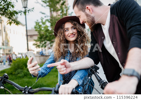 Travellers couple on electric scooters in small city, sightseeing. Young tourist using bikes during their summer trip, vacation. 115396224