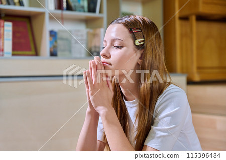 Upset sad teenage girl high school student sitting on floor in library classroom Upset sad teenage girl high school student sitting on floor in library classroom 115396484