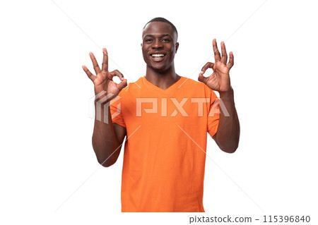 young american man in orange t-shirt feeling confident on white background with copy space 115396840