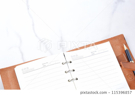 Image of doing desk work with a brown leather notebook Image of doing desk work with a brown leather notebook 115396857