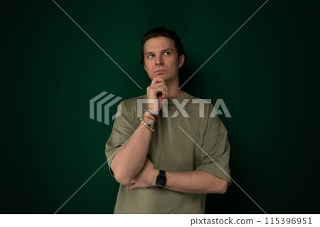 Man Standing in Front of Green Wall Man Standing in Front of Green Wall 115396951