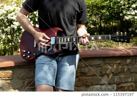 A man plays a beautiful guitar close-up 115397197