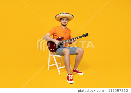 Attractive young guy playing guitar in mexican hat 115397210