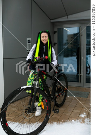 Woman Standing Next to Bike in Snow Woman Standing Next to Bike in Snow 115397859