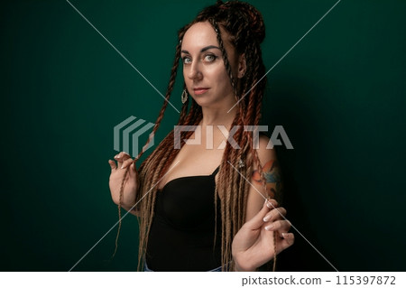 Woman With Dreadlocks Standing in Front of Green Wall 115397872