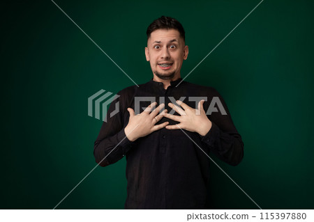 Man Pulling Funny Face in Front of Green Background Man Pulling Funny Face in Front of Green Background 115397880
