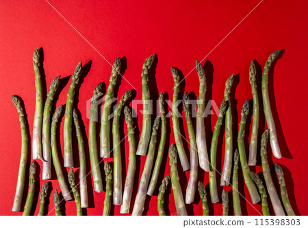 Green asparagus on red background. Vegetable food top view. 115398303