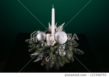 Candle Resting on Christmas Arrangement Candle Resting on Christmas Arrangement 115398755