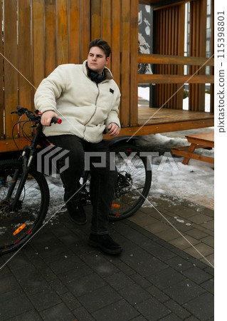 Lifestyle concept, young man sitting at a bus stop with a bicycle 115398801