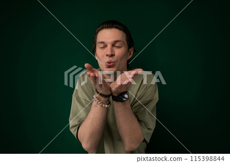 Man Standing in Front of Green Background With Hands Together Man Standing in Front of Green Background With Hands Together 115398844