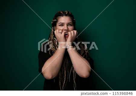 Woman With Dreadlocks Standing in Front of Green Wall Woman With Dreadlocks Standing in Front of Green Wall 115398846