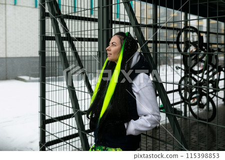 Woman Standing in Front of Metal Fence 115398853