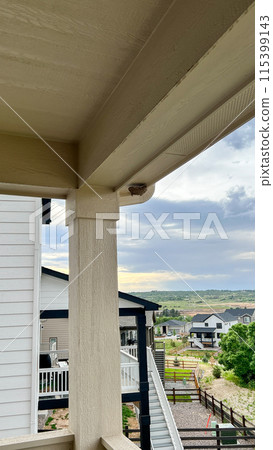 Close-up view of a cave sparro nest built under the eaves of a suburban house. The nest is securely tucked into the corner of the roof, showcasing the birds adaptability and nesting habits in urban Close-up view of a cave sparro nest built under the eaves of a suburban house. The nest is securely tucked into the corner of the roof, showcasing the birds adaptability and nesting habits in urban 115399143