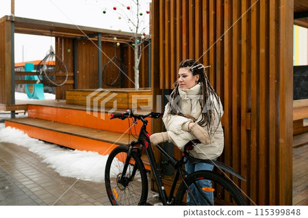 Woman With Dreadlocks Sitting on a Bike 115399848