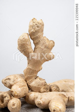Fresh ginger roots on gray stone background close-up. 115399948