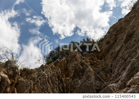 Rocky cliff with blue sky and clouds 115400543