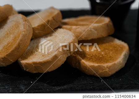 Pate with sauce and croutons on a black board on a white background Pate with sauce and croutons on a black board on a white background 115400634
