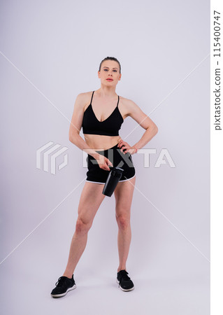 Sporty female drinking water after workout. Photo of fitness woman. Healthy lifestyle 115400747