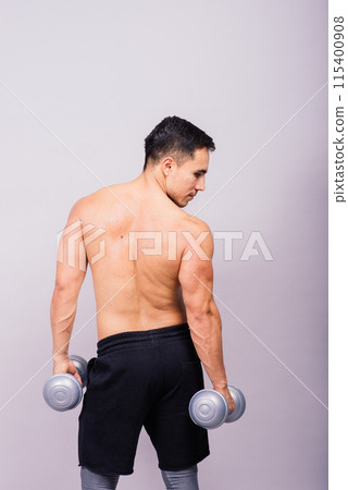 Shirtless bodybuilder showing his great body and holding dumbell. Shirtless bodybuilder showing his great body and holding dumbell. 115400908