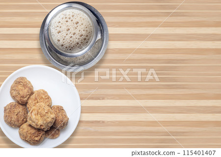Indian filter coffee with ooty varkey pastry served on wooden table. evening snack time Indian filter coffee with ooty varkey pastry served on wooden table. evening snack time 115401407
