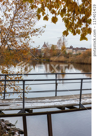 Autumn landscape with pier, trees branches and Shlisselburg Fortress Autumn landscape with pier, trees branches and Shlisselburg Fortress 115401419