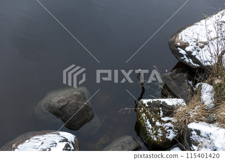 Autumn landscape with snow, stones and mooring pole Autumn landscape with snow, stones and mooring pole 115401420