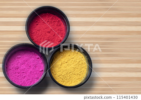 Three different holi festival color powder in black box on wooden table background. Three different holi festival color powder in black box on wooden table background. 115401430