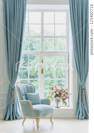 cozy light blue interior of the living room with chic beautiful antique furniture in baroque style. large windows in spacious room cozy light blue interior of the living room with chic beautiful antique furniture in baroque style. large windows in spacious room 115402719