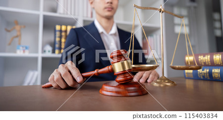 Professional Lawyer Signing Settlement Agreement in Office with Gavel and Scales of Justice on Desk Professional Lawyer Signing Settlement Agreement in Office with Gavel and Scales of Justice on Desk 115403834