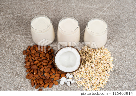 Types of plant-based milk in glasses. Oat, coconut and almond milk. 115403914