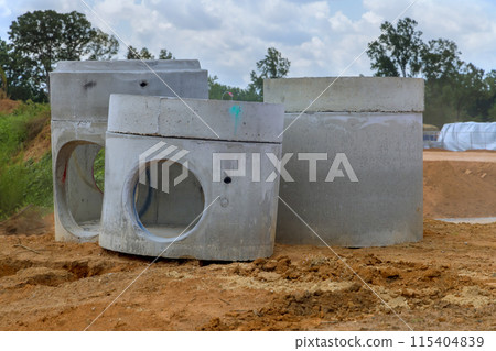 Stack of concrete drainage wells for water discharge prior to installation on construction site Stack of concrete drainage wells for water discharge prior to installation on construction site 115404839