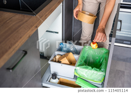 Woman throwing trash into household bins for waste sorting in the kitchen for recycle. Plastic, paper, bio and mixed waste. Sorting waste at home concept 115405114