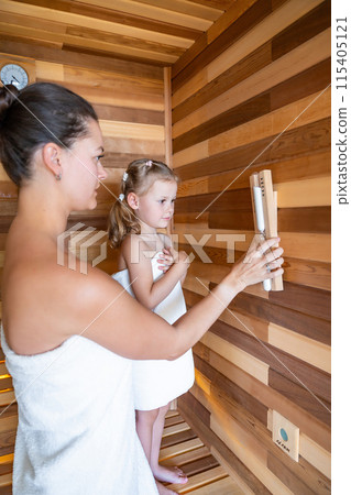 Mom and daughter control the time spent in the sauna enjoying time together. Girly pastime Mom and daughter control the time spent in the sauna enjoying time together. Girly pastime 115405121