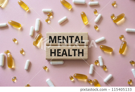 Mental Health symbol. Concept word Mental Health on wooden blocks. Beautiful pink background with pills. Medicine and Mental Health concept. Copy space 115405133