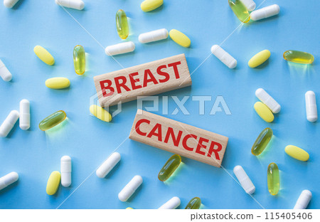 Breast cancer symbol. Wooden blocks with words Breast cancer. Beautiful blue background with pills. Medicine and Breast cancer concept. Copy space. 115405406
