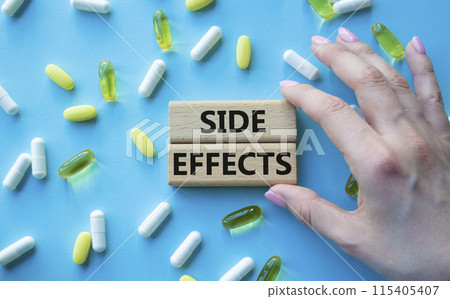 Side Effects symbol. Wooden blocks with words Side Effects. Beautiful blue background with pills. Doctor hand. Medicine and Side Effects concept. Copy space. 115405407