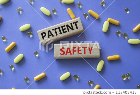 Patient Safety symbol. Concept word Patient Safety on wooden blocks. Beautiful purple background with pills. Medicine and Patient Safety concept. Copy space 115405415