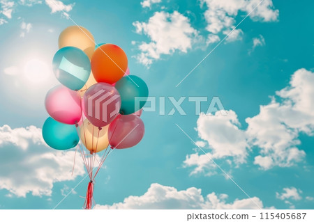 Colorful balloons floating against blue sky with clouds 115405687