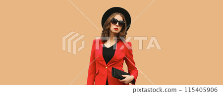 Stylish elegant woman posing in business suit, red blazer jacket, black round hat with handbag 115405906