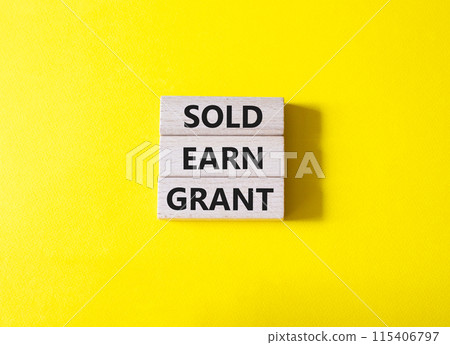 Sold Earn Grant symbol. Concept words Sold Earn Grant on wooden blocks. Beautiful yellow background. Business and Sold Earn Grant concept. Copy space. 115406797