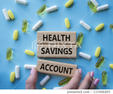 Health Saving Account symbol. Concept word Health Saving Account on wooden blocks. Doctor hand. Beautiful blue background with pills. Medicine and Health Saving Account concept. Copy space 115406805
