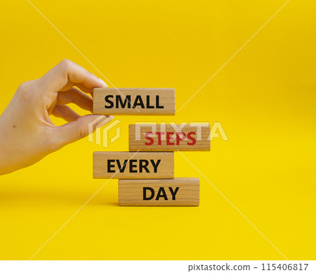 Small Steps Every Day symbol. Wooden blocks with words Small Steps Every Day. Beautiful yellow background. Businessman hand. Business and Small Steps Every Day concept. Copy space. 115406817