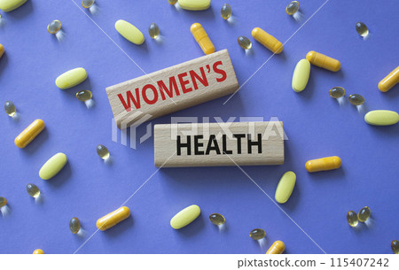 Womens health symbol. Concept word Womens health on wooden blocks. Beautiful purple background with pills. Medicine and Womens health concept. Copy space Womens health symbol. Concept word Womens health on wooden blocks. Beautiful purple background with pills. Medicine and Womens health concept. Copy space 115407242