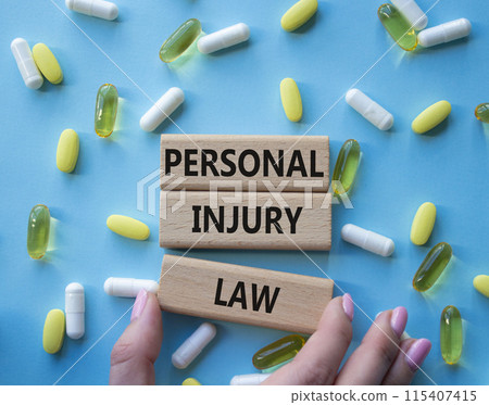 Personal Injury Law symbol. Concept words Personal Injury Law on wooden blocks. Beautiful blue background with pills. Doctor hand. Healthcare and Personal Injury Law concept. Copy space. 115407415