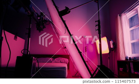 Professional video shoot studio. Behind the scenes of video commercial production shooting set. Silhouette of camera and equipment in studio. Making of online film advertising on set. Selective focus. Professional video shoot studio. Behind the scenes of video commercial production shooting set. Silhouette of camera and equipment in studio. Making of online film advertising on set. Selective focus. 115407573